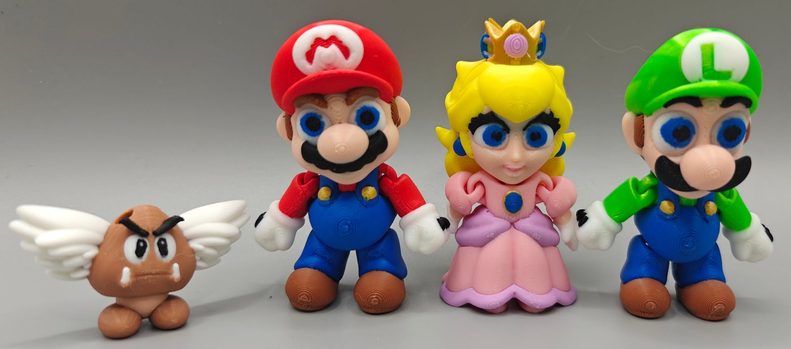 Miniaturas coloridas de Mario, Luigi, Princesa Peach e Goomba alado impressas em 3D
